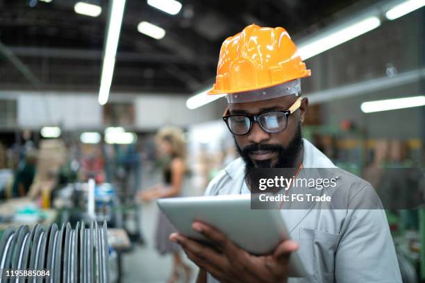 ingeniero usando tabletas y trabajando en fábrica - control de calidad fotografías e imágenes de stock