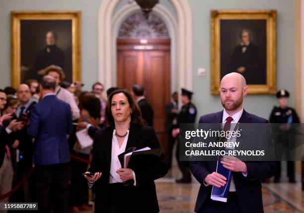 Senator Kamala Harris speaks with a staff member during a break on the fourth day of the Senate impeachment trial of US President Donald Trump in...