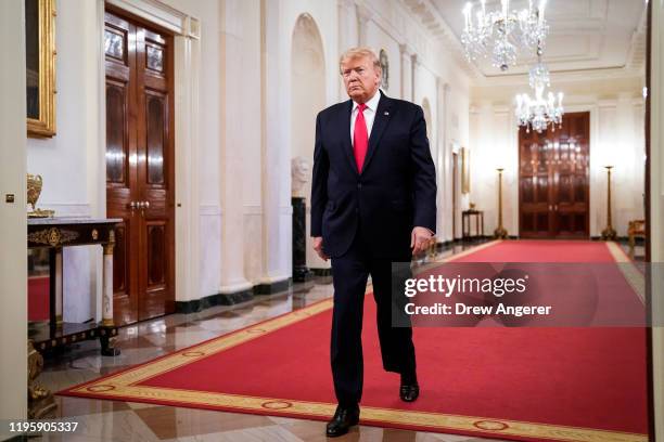 President Donald Trump walks down the Cross Hall toward East Room of the White House for an event with U.S. Mayors on January 24, 2020 in Washington,...