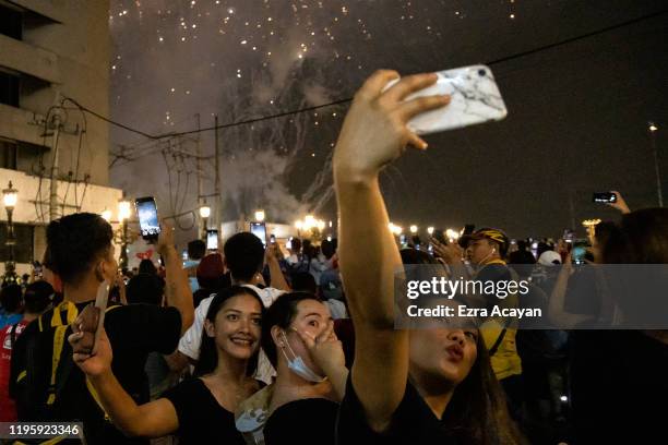 Filipinos take pictures as fireworks explode over Chinatown during Chinese New Year's eve celebrations on January 25, 2020 in Manila, Philippines....