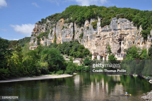 the dordogne river under a stone cliff in la roque-gageac village - dordogne river stock pictures, royalty-free photos & images