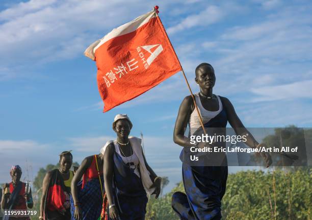 Mundari tribe women with a chinese flag celebrating a wedding, Central Equatoria, Terekeka, South Sudan on November 26, 2019 in Terekeka, South Sudan.