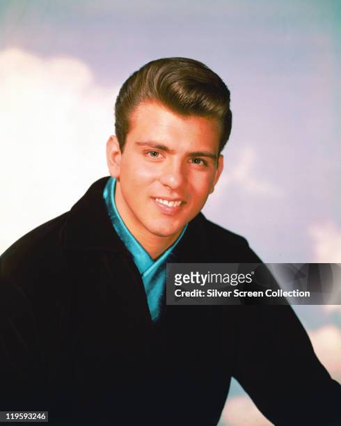 Fabian , US singer and actor, poses win a studio portrait, wearing a black jacket and blue shirt, circa 1960.