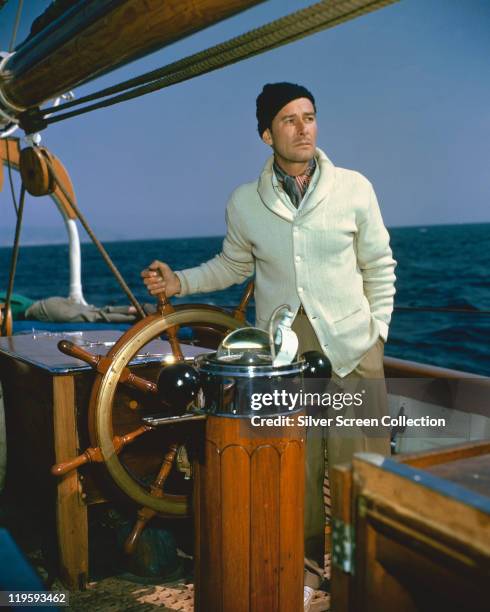 Errol Flynn , Australian actor, at the wheel of his schooner, 'The Zaca', in a publicity still issued for the film, 'Cruise of the Zaca', 1952. The...