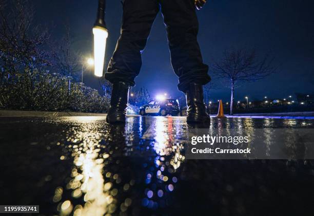 unrecognizable police officers in rainy night police control. - arrest warrant stock pictures, royalty-free photos & images