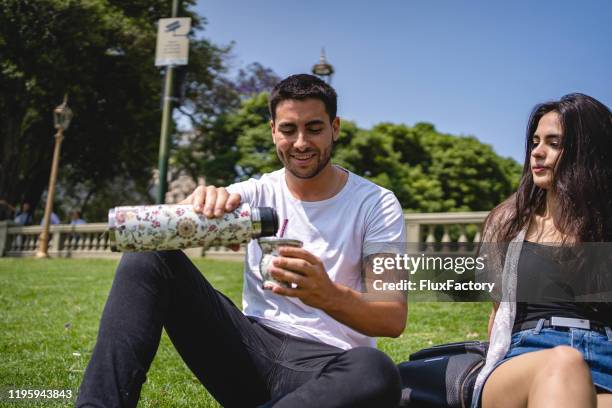 pareja tomando un descanso de caminar para beber jugo - yerba mate fotografías e imágenes de stock
