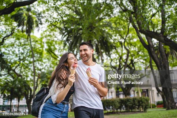 couple eating sweet refreshments during a public park date - argentina friendly stock pictures, royalty-free photos & images