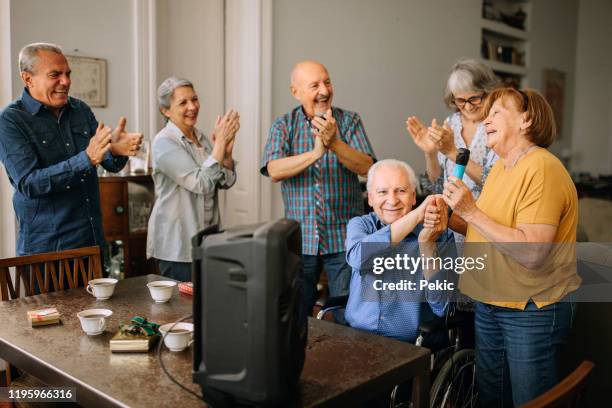 senior man celebrating birthday with friends in nursing home - retirement background stock pictures, royalty-free photos & images
