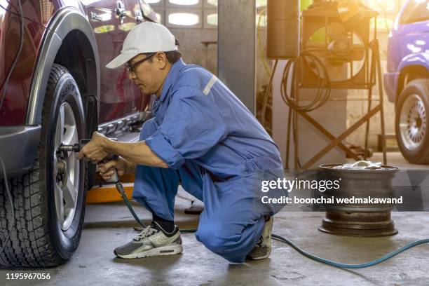 a mechanic repairs a truck. replace brake disc and pads - vrachtwagen banden stockfoto's en -beelden