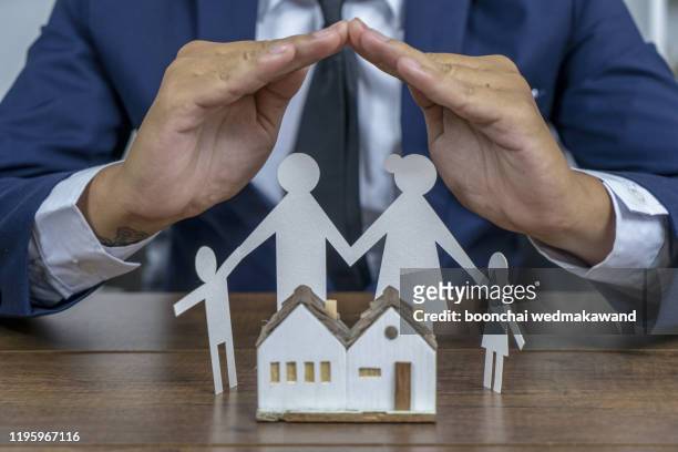 insurer protecting a family with his hands; multiple exposure - insurance stock pictures, royalty-free photos & images