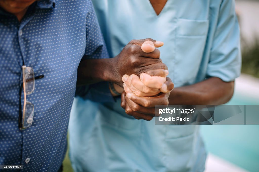 Male nurse assisting senior man in nursing home