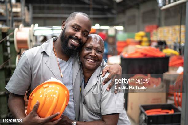 portrait of coworkers embracing in industry - employee bonding stock pictures, royalty-free photos & images