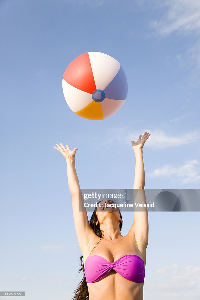 Woman catching colorful beach ball