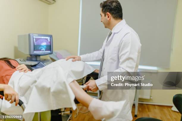 mujer en silla ginecológica durante el chequeo ginecológico con su médico. el ginecólogo examina a una mujer - pelvic exam fotografías e imágenes de stock