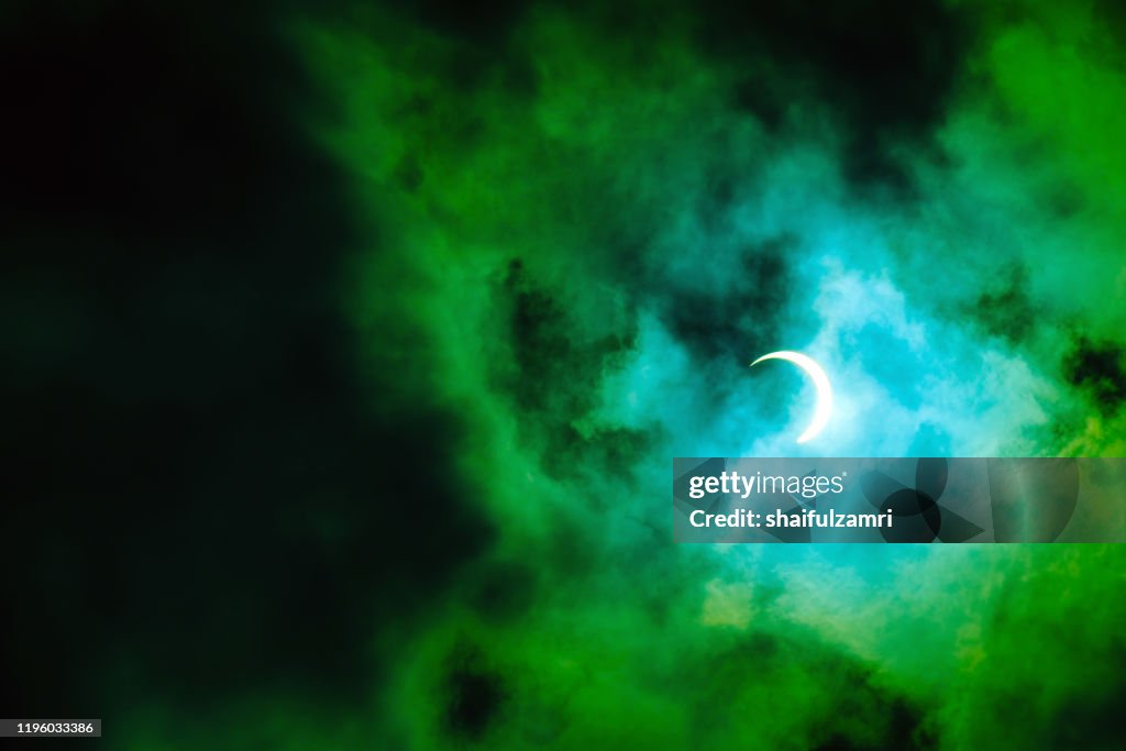 View of partial annular solar eclipse in Kuala Lumpur with dramatic colour.