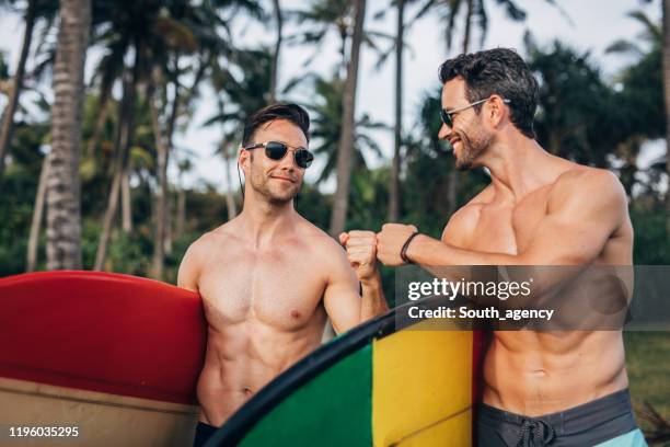 two handsome men going surfing - muscle men at beach stock pictures, royalty-free photos & images