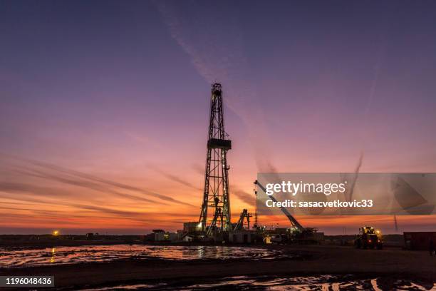 plataforma petrolífera de fracking al amanecer - fracking fotografías e imágenes de stock