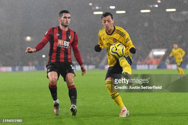 Mesut Ozil of Arsenal battles for possession with Lewis Cook of AFC Bournemouth during the Premier League match between AFC Bournemouth and Arsenal...