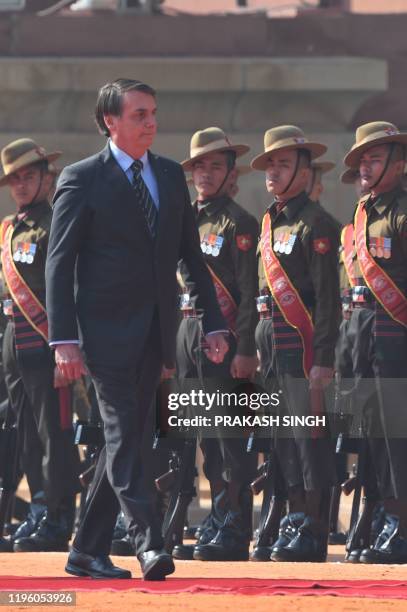 Brazil's President Jair Bolsonaro inspects the guard of honor during a ceremonial reception at the Presidential palace in New Delhi on January 25,...