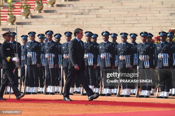 Brazil's President Jair Bolsonaro inspects the guard of honor during a ceremonial reception at the Presidential palace in New Delhi on January 25,...