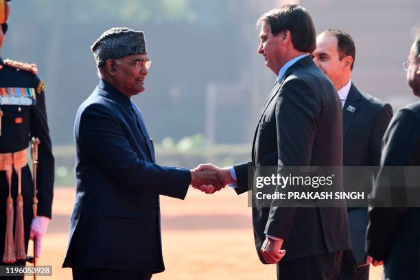 Brazil's President Jair Bolsonaro inspect the guard of honor during a ceremonial reception at the Presidential palace in New Delhi on January 25,...