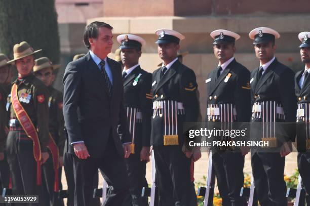 Brazil's President Jair Bolsonaro inspects the guard of honor during a ceremonial reception at the Presidential palace in New Delhi on January 25,...