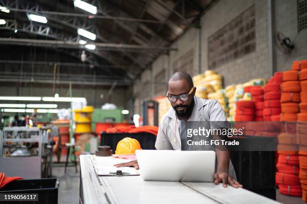 engineer working at the factory using laptop - manufacturing stock pictures, royalty-free photos & images