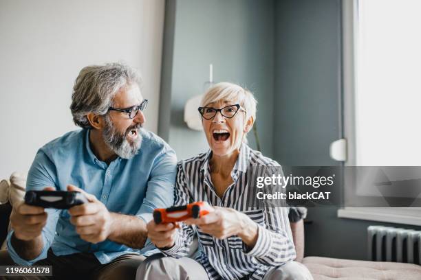 seniors playing video games - jovem de espírito imagens e fotografias de stock