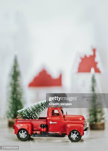 cute little red car toy truck with christmas tree on white wooden background - christmas truck stock pictures, royalty-free photos & images