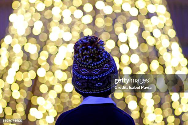 boy standing against illuminated lights - zauberer darstellender künstler stock-fotos und bilder
