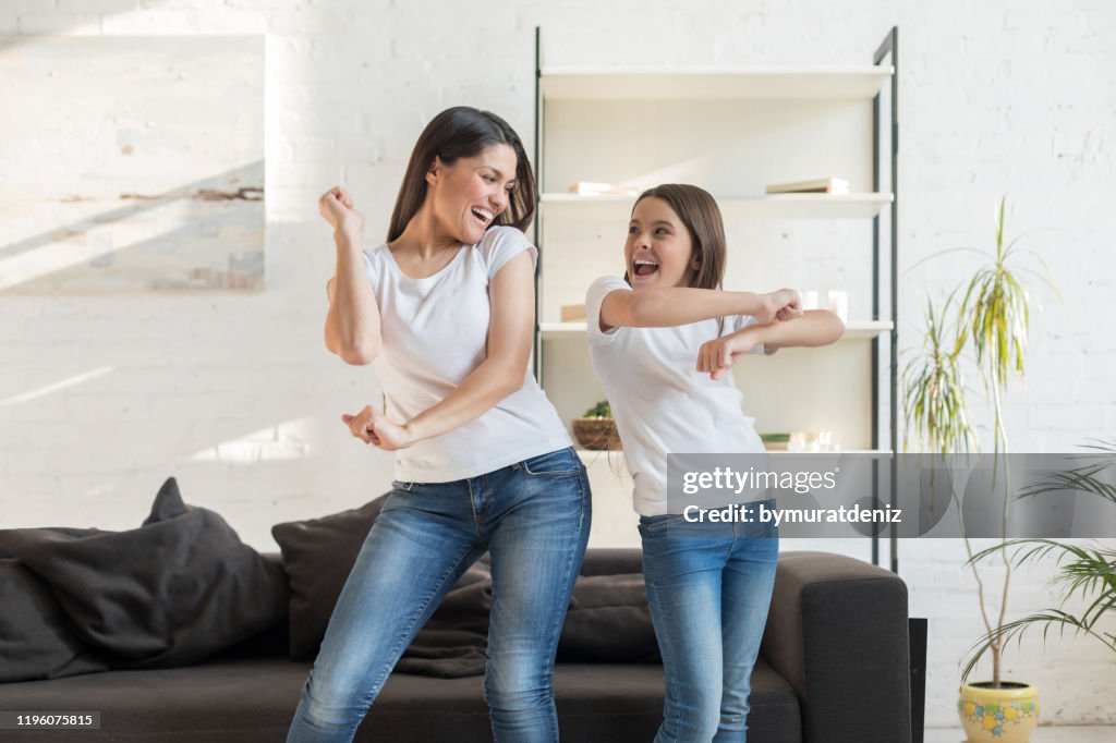Mama mit Kind Mädchen tanzen im Wohnzimmer