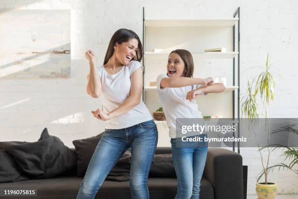 mamá con niña bailando en la sala de estar - bailar fotografías e imágenes de stock