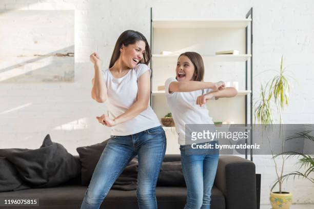 mom with kid girl dancing in living room - daughter stock pictures, royalty-free photos & images