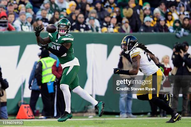 Le'Veon Bell of the New York Jets catches a pass under pressure from Mark Barron of the Pittsburgh Steelers at MetLife Stadium on December 22, 2019...