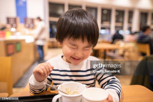 little boy satisfied with delicious ramen in food court - food court stock pictures, royalty-free photos & images