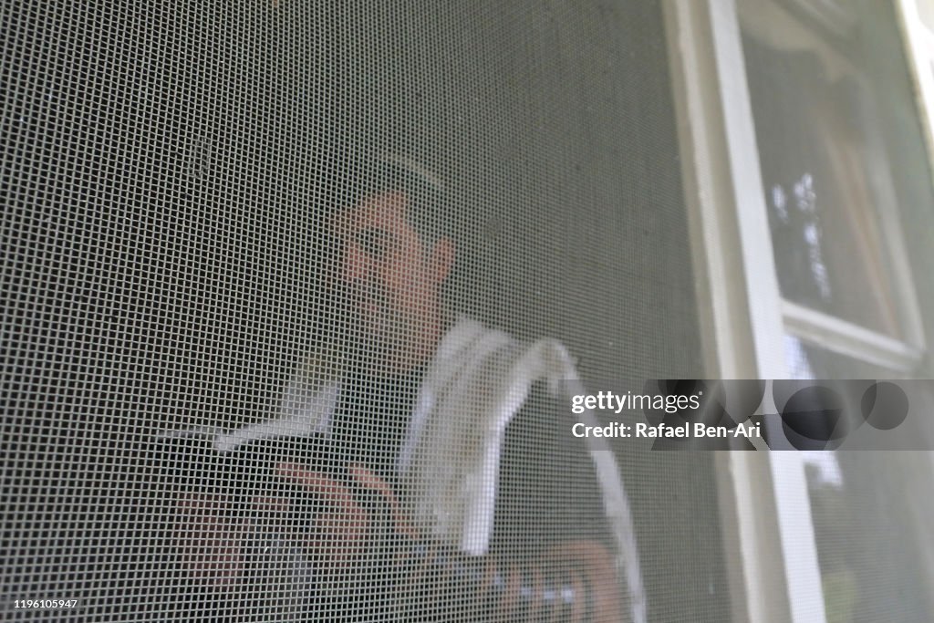 Jewish man wearing Tallit and Tefillin praying