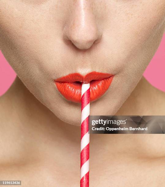 close up of female drinking through straw - rietje stockfoto's en -beelden