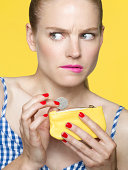 worried looking woman dropping coins in her purse
