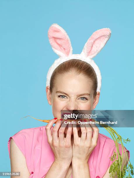 female wearing rabbit ears and biting a carrot - costume rabbit ears stock pictures, royalty-free photos & images
