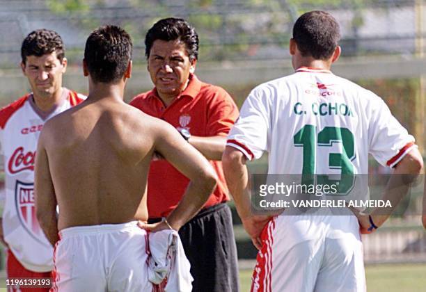 Necaxa's coach Raul Arias speaks with members of his team 12 January during training for the World Club Championship in Brazil. El director tecnico...