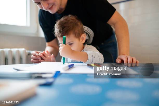 cute left handed boy drawing at home - left hand stock pictures, royalty-free photos & images