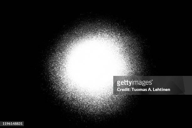 close-up of a white spray paint spot, isolated on black background. - spray paint stock pictures, royalty-free photos & images