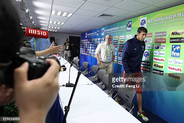 Michael Phelps and coach Bob Bowman of the United States walk out of the room after participating in a press conference on Day Eight of the 14th FINA...
