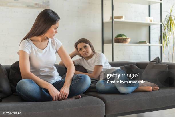 child and mother sitting on sofa not talking - stubborn stock pictures, royalty-free photos & images