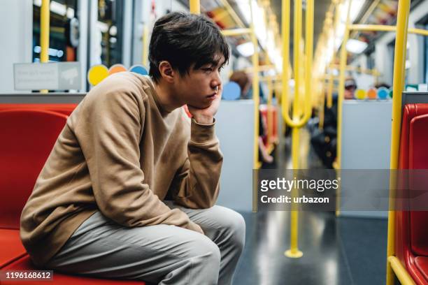 verdrietig tiener jongen in de metro - sad commuter stockfoto's en -beelden