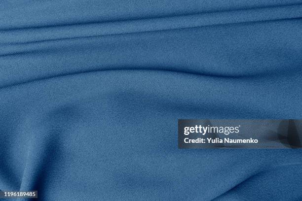 folded piece of blue fabric, folds of fabric. beautiful texture of blue color. a piece of fabric for a seamstress cut. - satin bildbanksfoton och bilder