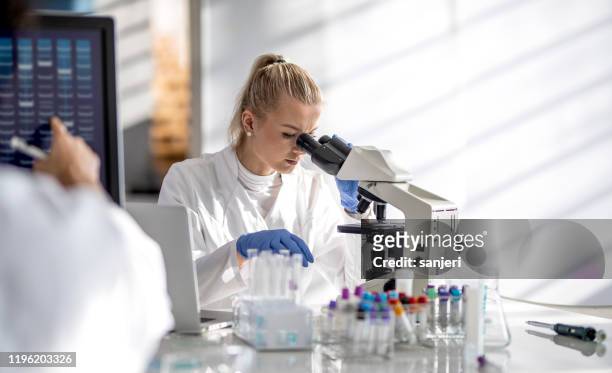 female scientist looking through a microscope - groundbreaking female scientists stock pictures, royalty-free photos & images