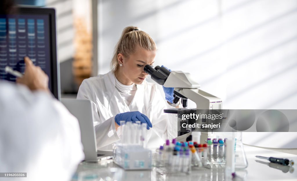 Female scientist looking through a microscope