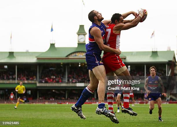 Adam Goodes of the Swans takes a mark in front of Ben Hudson of the Bulldogs during the round 18 AFL match between the Sydney Swans and the Western...