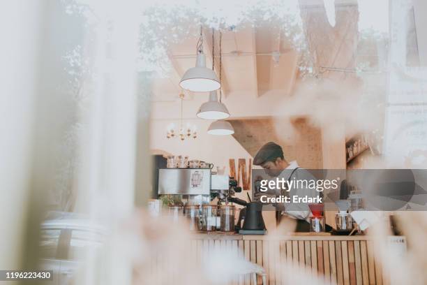 thai male barista making cappuccino at coffee shop stock photo - busy coffee shop stock pictures, royalty-free photos & images